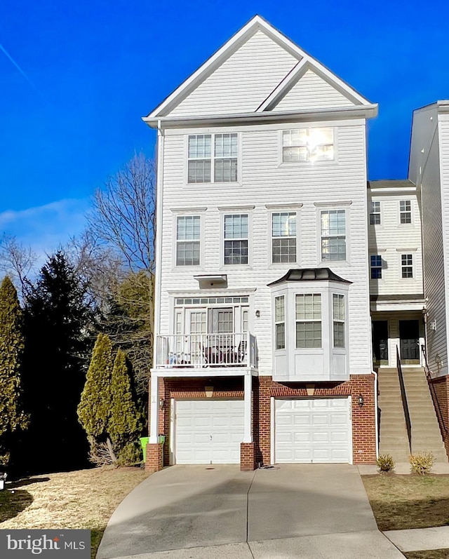 multi unit property with brick siding, an attached garage, and driveway