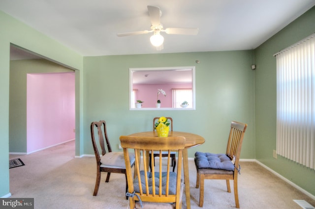 carpeted dining area with visible vents, baseboards, and ceiling fan