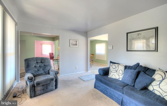 carpeted living room featuring baseboards