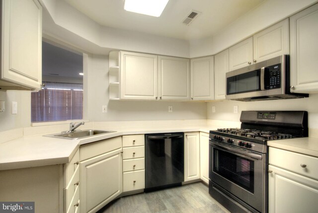 kitchen with visible vents, light countertops, light wood-style flooring, appliances with stainless steel finishes, and a sink