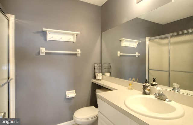 full bathroom with a shower with shower door, toilet, and vanity