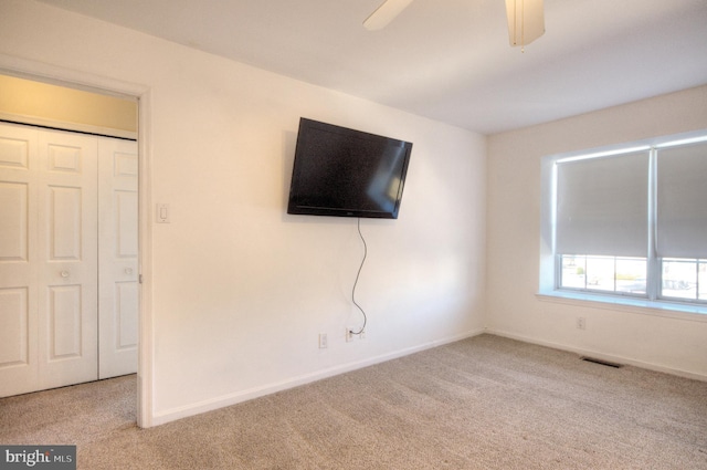 unfurnished bedroom with visible vents, carpet flooring, a ceiling fan, and baseboards