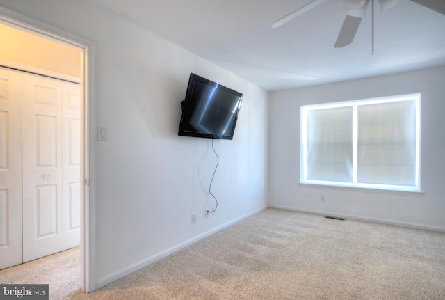 unfurnished living room with a ceiling fan, visible vents, carpet floors, and baseboards