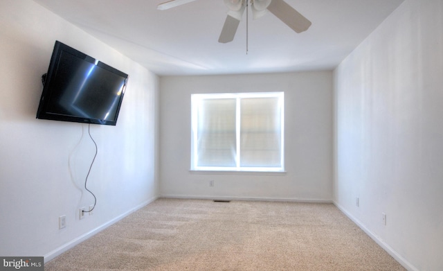 spare room featuring a ceiling fan, baseboards, and carpet floors