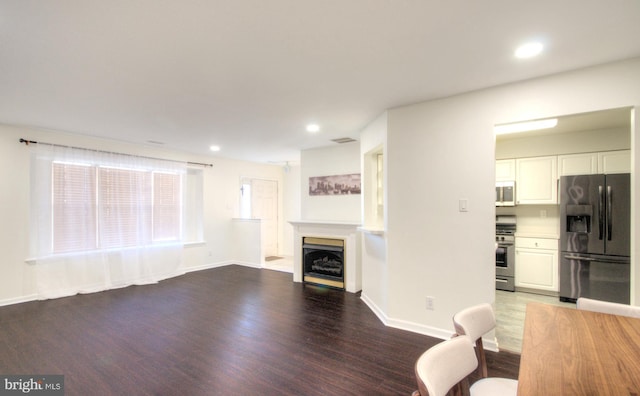 unfurnished living room featuring recessed lighting, visible vents, wood finished floors, and a fireplace