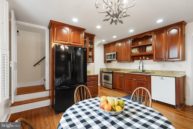 kitchen featuring a sink, open shelves, recessed lighting, stainless steel appliances, and light wood-style floors