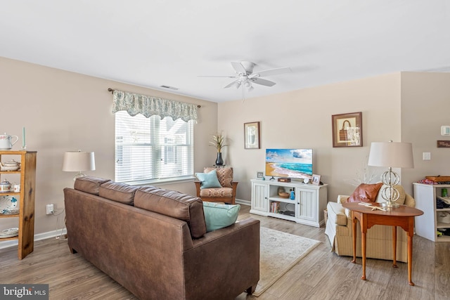 living room featuring visible vents, wood finished floors, baseboards, and ceiling fan