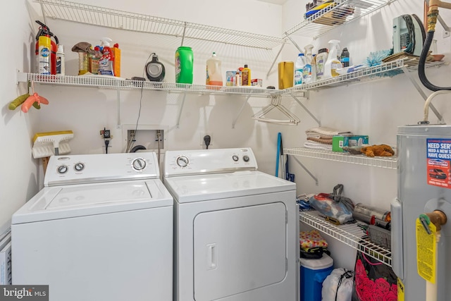 laundry room featuring washing machine and clothes dryer, laundry area, and water heater