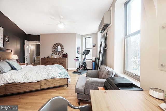 bedroom featuring baseboards, multiple windows, and light wood-style floors