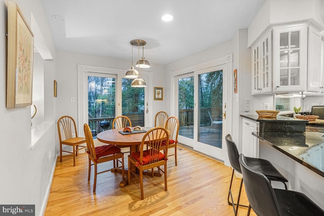 dining room with light wood finished floors, recessed lighting, and baseboards