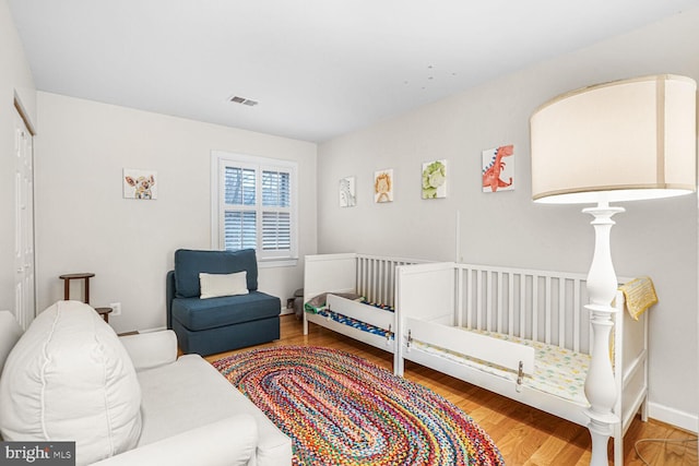 bedroom featuring visible vents and wood finished floors