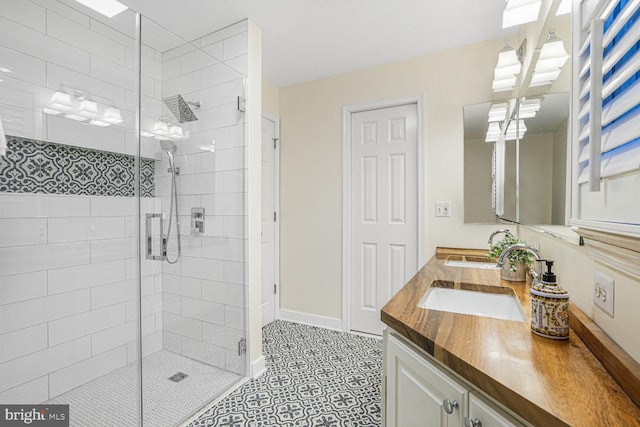 bathroom featuring a stall shower, vanity, and baseboards