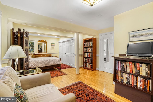 bedroom featuring multiple closets, baseboards, and wood finished floors