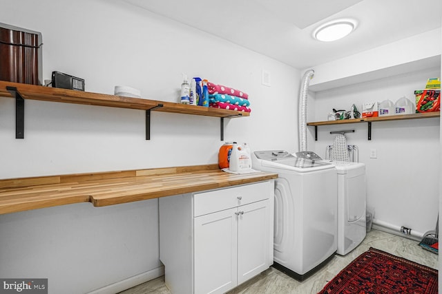 laundry room with cabinet space, baseboards, and separate washer and dryer