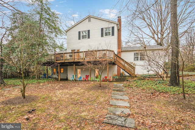 rear view of property featuring stairs, a chimney, and a wooden deck