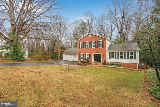 view of front facade with a garage, driveway, brick siding, and a front yard