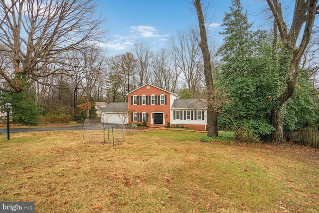 view of front of property with a garage, brick siding, aphalt driveway, fence, and a front yard