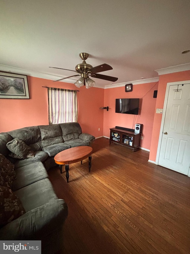 living room featuring ceiling fan, ornamental molding, wood finished floors, and baseboards