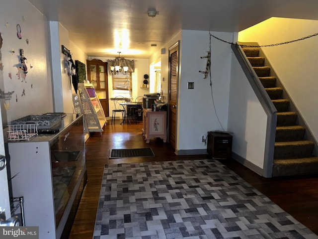 interior space with a notable chandelier, stairs, baseboards, and dark wood-type flooring