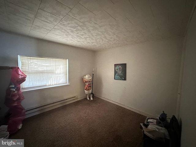 carpeted spare room with a baseboard heating unit