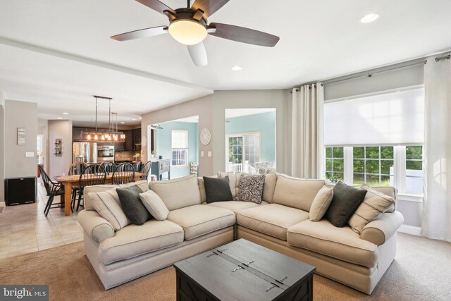 living room featuring light carpet, ceiling fan with notable chandelier, light tile patterned flooring, and recessed lighting