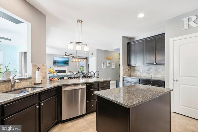 kitchen featuring decorative backsplash, a ceiling fan, dark stone counters, stainless steel dishwasher, and a sink