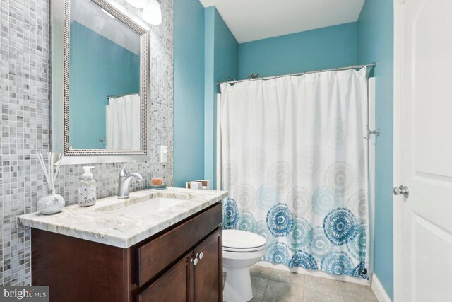 full bathroom featuring tasteful backsplash, a shower with shower curtain, toilet, vanity, and tile patterned flooring