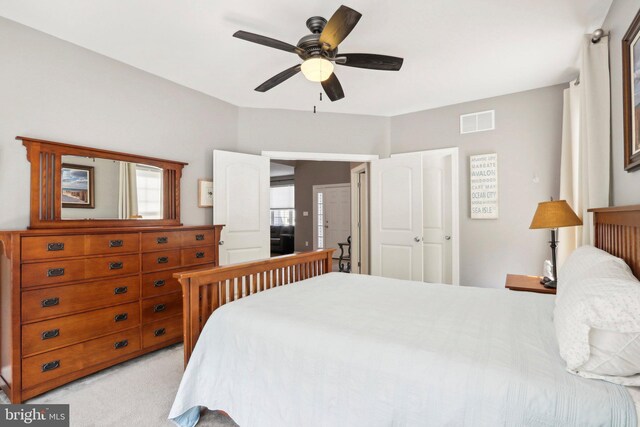 bedroom with visible vents, ceiling fan, and light carpet