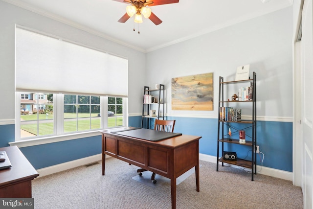 carpeted home office with baseboards, visible vents, ornamental molding, and a ceiling fan