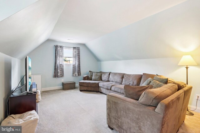 living area featuring vaulted ceiling, carpet, and baseboards