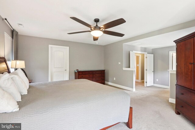 bedroom featuring light colored carpet, ceiling fan, visible vents, and baseboards