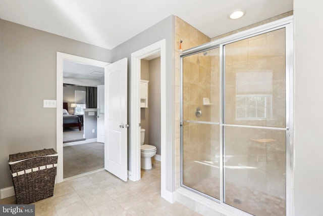 full bathroom featuring toilet, a shower stall, tile patterned flooring, and ensuite bathroom