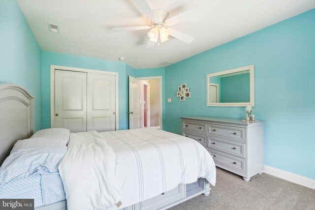 bedroom featuring ceiling fan, light carpet, visible vents, baseboards, and a closet