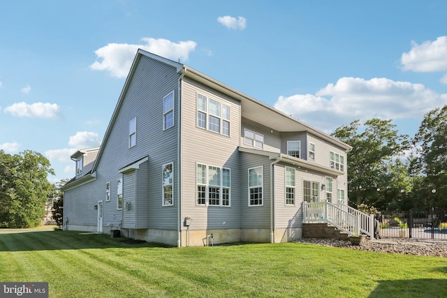 back of property featuring a lawn, cooling unit, and fence