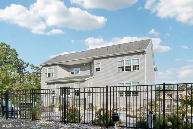 rear view of property featuring fence