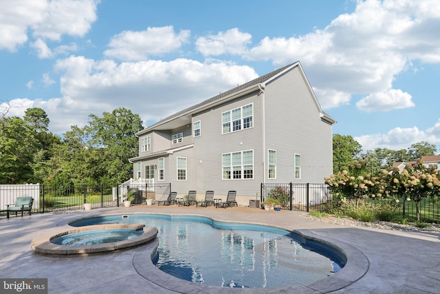 view of pool featuring a pool with connected hot tub, fence, and a patio