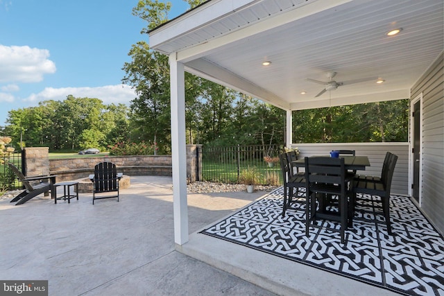 view of patio with outdoor dining area, fence, and a ceiling fan