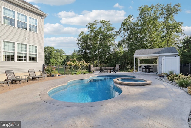 view of pool with a pool with connected hot tub, fence, and a patio