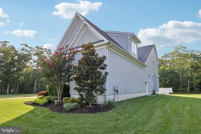 view of property exterior with a shingled roof and a lawn