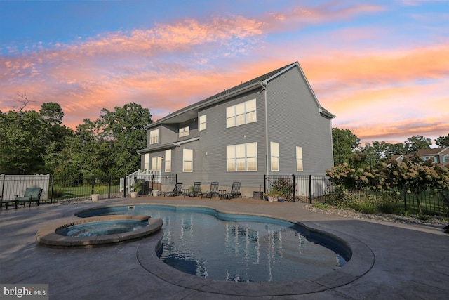 view of swimming pool with a pool with connected hot tub, a patio area, and fence