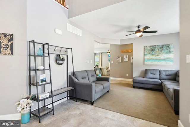 living room with ceiling fan, light carpet, visible vents, and baseboards