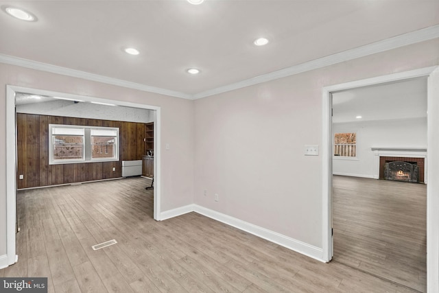 spare room featuring baseboards, ornamental molding, and wood finished floors