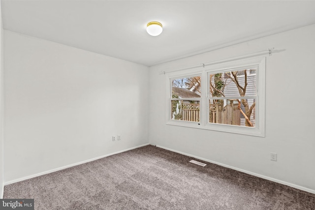 carpeted empty room featuring baseboards and visible vents