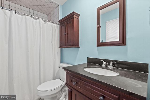 bathroom featuring toilet, curtained shower, and vanity