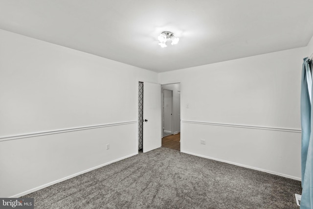 carpeted empty room with baseboards