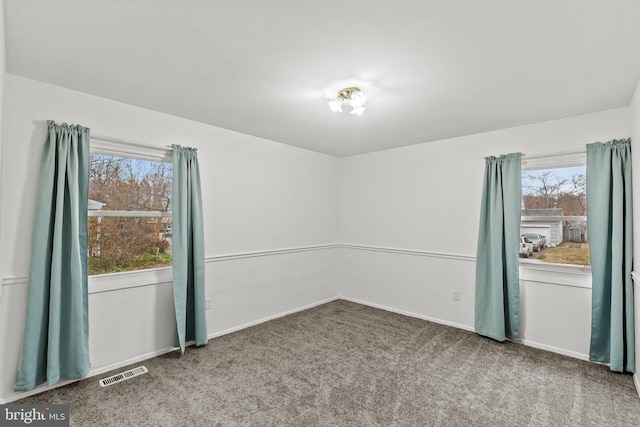 unfurnished room featuring baseboards, visible vents, and carpet flooring