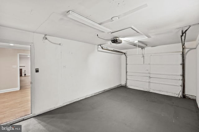 garage with a garage door opener and baseboards