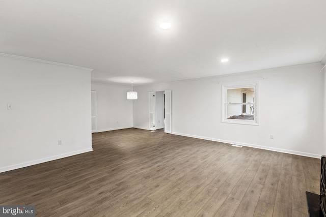 unfurnished room featuring dark wood-style floors, crown molding, and baseboards