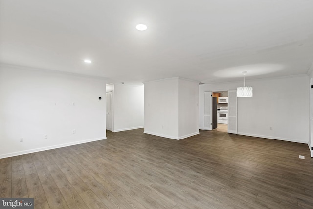 interior space with dark wood-type flooring, recessed lighting, ornamental molding, and baseboards