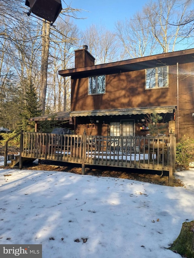 chalet / cabin with a chimney and a wooden deck